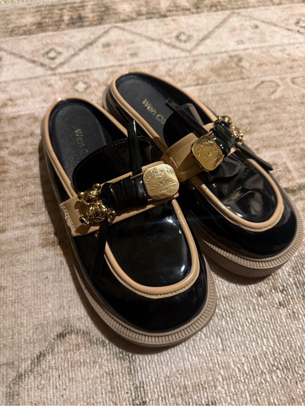 Glossy Black Loafers with Beige Trim and Gold Emblems